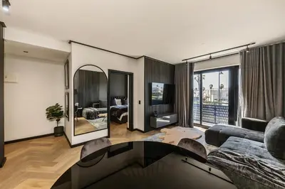 a living room with a couch and a mirror at The Archetype - Nine Palms Luxury Apartments in Cape Town