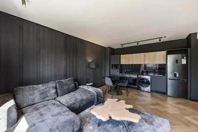 a living room with a couch and a kitchen at The Archetype - Nine Palms Luxury Apartments in Cape Town