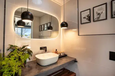 a bathroom with a white sink and a mirror at In-a-Tree in Paarl