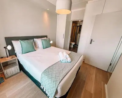 a bedroom with a bed with two towels on it at Cape Mae Apartment Hotel in Cape Town