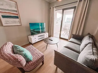 a living room with a couch and a flat screen tv at Cape Mae Apartment Hotel in Cape Town