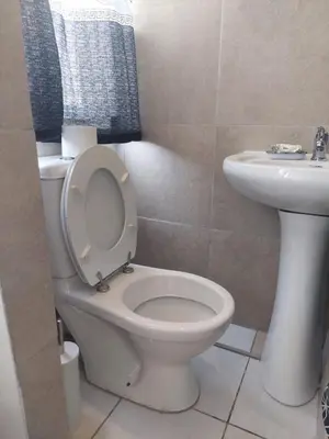 a bathroom with a white toilet and a sink at KK Guesthouse in Cape Town