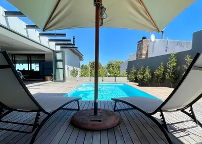 a patio with two chairs and an umbrella next to a pool at The View in Cape Town