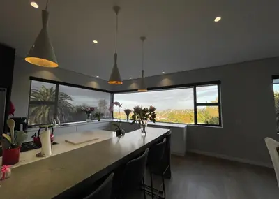 a kitchen with a large counter with chairs and windows at The View in Cape Town