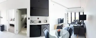 a living room with a table and a dining room at Greystone Executive Apartments in Cape Town