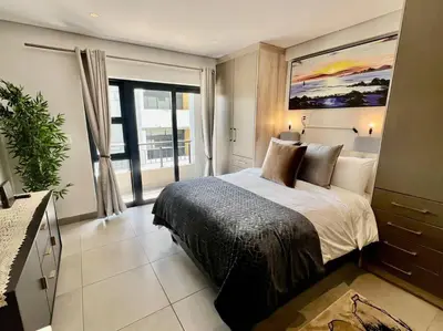 a bedroom with a bed and a large window at The Den at 41- Parking included in Stellenbosch