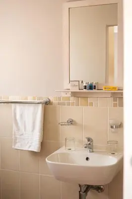 a bathroom with a sink and a mirror at Ilanga Du Cap Hotel in Cape Town