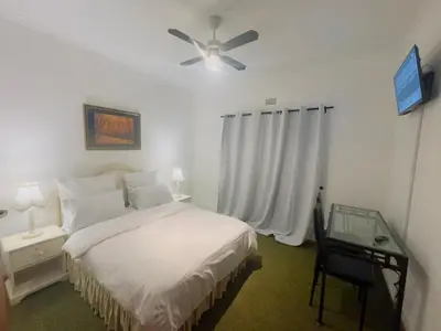 a bedroom with a bed and a ceiling fan at Leisure Lodges Middle Room in Cape Town