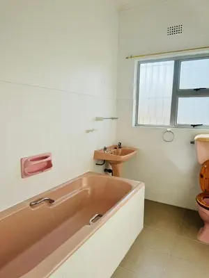 a bathroom with a pink tub and a sink at Leisure Lodges Middle Room in Cape Town