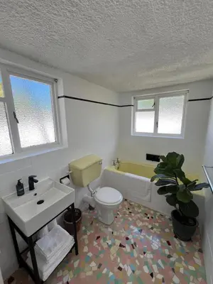 a bathroom with a toilet and a tub and a sink at Lala Panzi House - Grotto Beach, Voëlklip in Hermanus