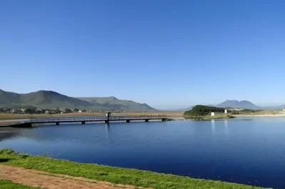 a bridge over a body of water with mountains in the background at Our Nest Guest House in Kleinmond