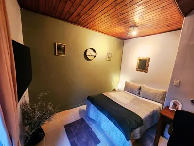 a bedroom with a bed and a wooden ceiling at Budget Haven Durbanville in Cape Town
