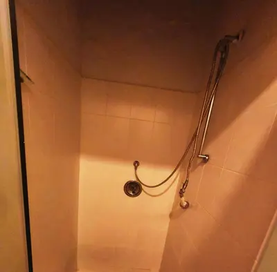a shower with a hose in a bathroom with at Budget Haven Durbanville in Cape Town