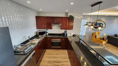 a kitchen with wooden cabinets and a counter top at Capri 504, Island Club, Century City in Cape Town