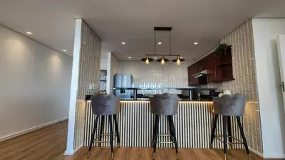 a kitchen with two bar stools in front of a counter at Capri 504, Island Club, Century City in Cape Town