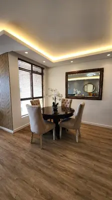 a dining room with a table and chairs and a mirror at Capri 504, Island Club, Century City in Cape Town