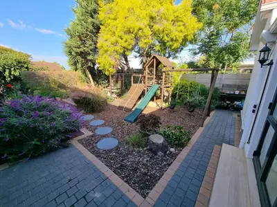 a playground with a slide in a yard at Spacious Lanes Cottage and Garage Parking in Cape Town