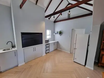a large kitchen with a large flat screen tv at Spacious Lanes Cottage and Garage Parking in Cape Town
