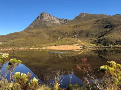a reflection of a mountain in a body of water at Babylons Tower Cottage in Caledon
