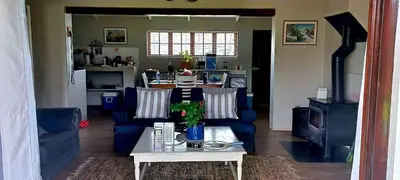 a living room with blue couches and a table at Babylons Tower Cottage in Caledon
