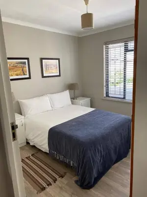 a bedroom with a large bed and a window at no 5 King Street, Onrus in Hermanus