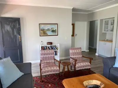 a living room with a couch and chairs and a table at no 5 King Street, Onrus in Hermanus