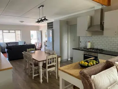 a kitchen and living room with a table and chairs at no 5 King Street, Onrus in Hermanus