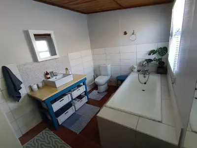 a bathroom with a tub and a sink and a toilet at Sunset Splendour in Pringle Bay