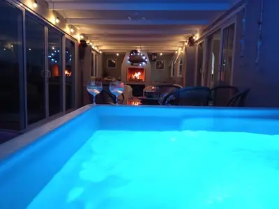 a swimming pool at night with glasses of wine at Sunset Splendour in Pringle Bay