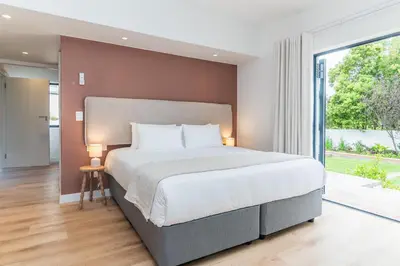 a bedroom with a large bed and a large window at Maison la Bruyere, 8p villa - heated pool, airco & hottub in Franschhoek