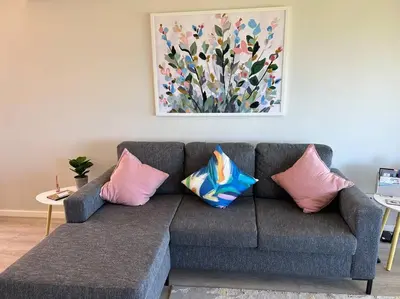a couch with pillows in a living room with a painting at 24 Whale Rock Estate in Hermanus