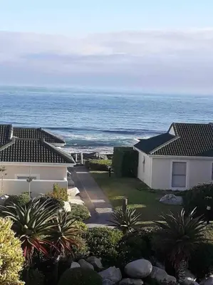 a view of a house and the ocean at 24 Whale Rock Estate in Hermanus