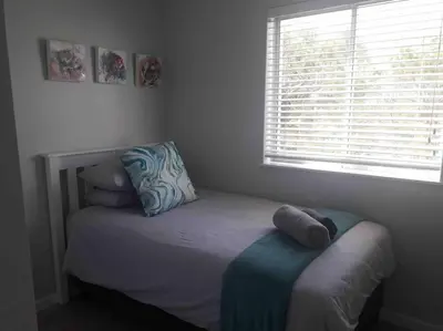 a small bed in a bedroom with a window at 24 Whale Rock Estate in Hermanus