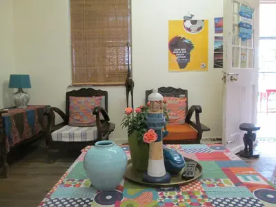 a living room with a table with a vase at Lighthouse Farm Backpackers Lodge in Cape Town