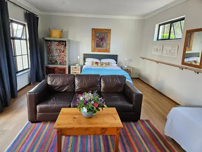 a living room with a couch and a bed at Studio on Main in Hermanus