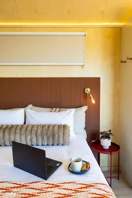 a laptop on a bed with a plate of food on it at Stellenbosch Farm Cabin - Klein Frans in Stellenbosch