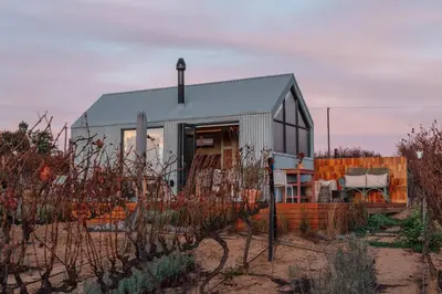 a small house in the middle of a field at Stellenbosch Farm Cabin - Klein Frans in Stellenbosch