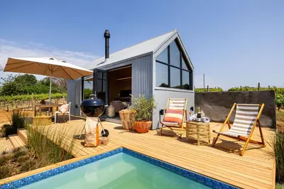 a backyard with a swimming pool and a tiny house at Stellenbosch Farm Cabin - Klein Frans in Stellenbosch