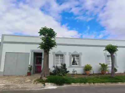 a white house with two trees in front of it at The Pink Door in Caledon