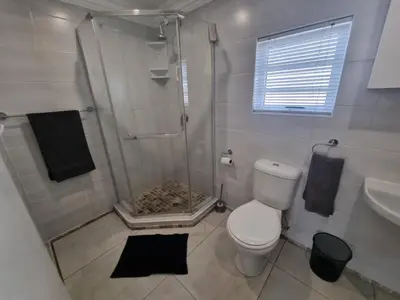 a bathroom with a shower and a toilet and a sink at 1 On Sonnet Unit Elaine in Cape Town