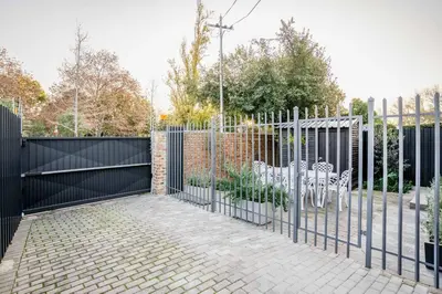 a black gate with chairs and a fence at Avemore Vredehof 1 with backup power in Stellenbosch