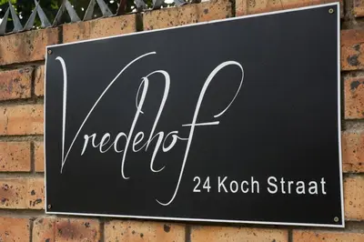 a sign on the side of a brick wall at Avemore Vredehof 1 with backup power in Stellenbosch
