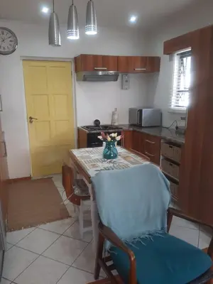 a kitchen with a table and a yellow door at Local & comfortable in Mandalay