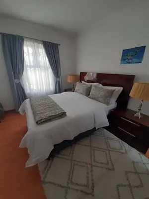 a bedroom with a large bed and a rug at Local & comfortable in Mandalay