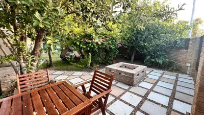 two wooden benches and a fire pit in a garden at NamaStay in Cape Town