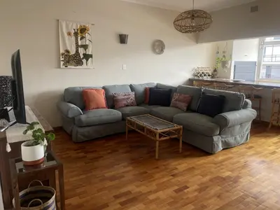 a living room with a couch and a table at The Beachside Nest in Cape Town