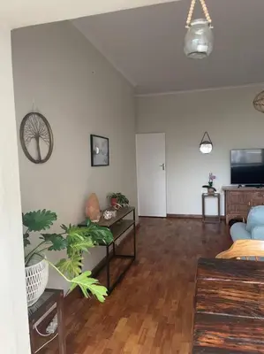 a living room with a couch and a tv at The Beachside Nest in Cape Town