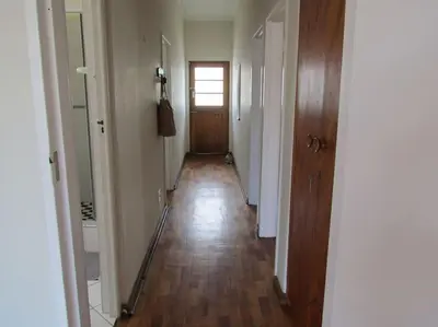a hallway of an apartment with a wooden floor at The Beachside Nest in Cape Town