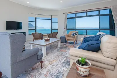 a living room with a couch and a table at Seafront Penthouse - Marine Court Hermanus in Hermanus