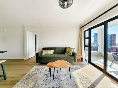 a living room with a couch and a table at Canal, Mountains, Sea Views, Pool, Gym, Parking, Wifi in Cape Town